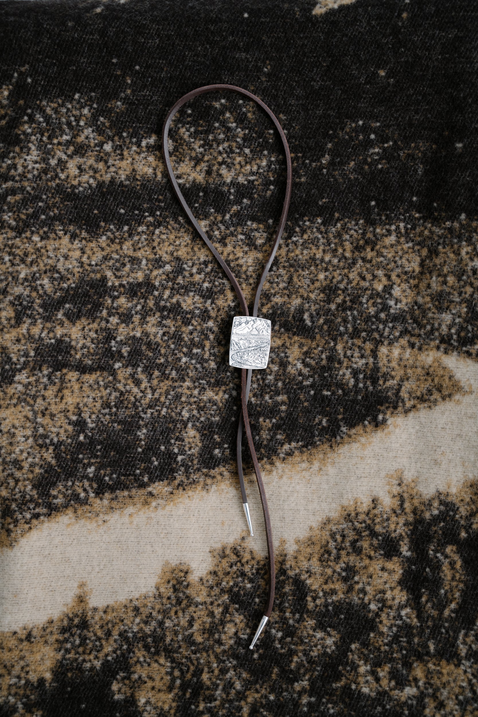 O.P Jewellery Snake River Bolo Tie with an engraved silver slide on the patterned wool Snake River Blanket.